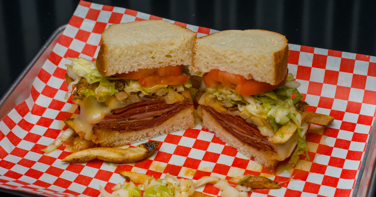 Oversized deli sandwich with hand-cut fries, house slaw, tomatoes, melted cheese, and premium meats at BIGGIES for the best deli near Green Valley Henderson